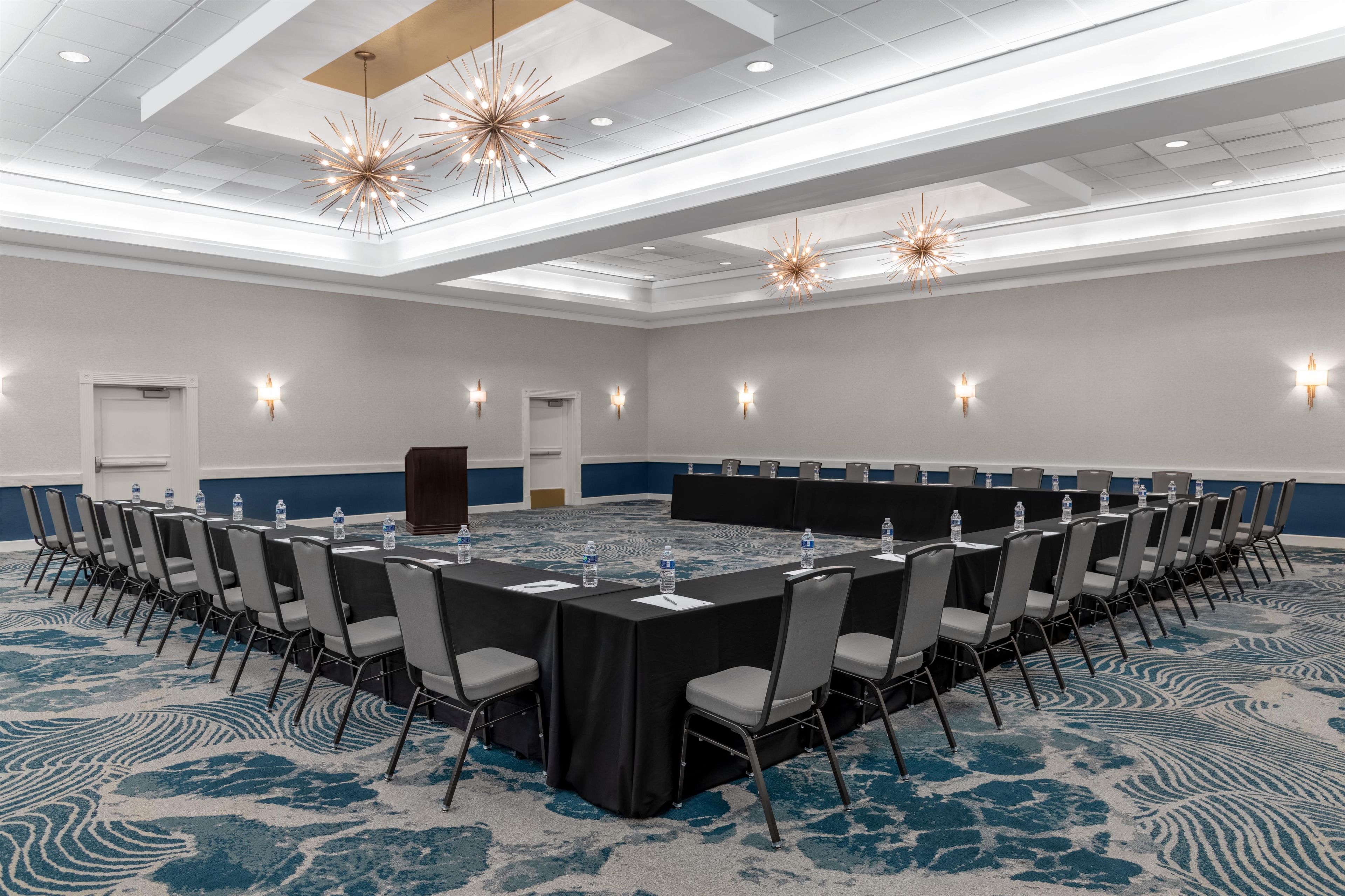 A conference room with a long table, chairs, and water bottles.