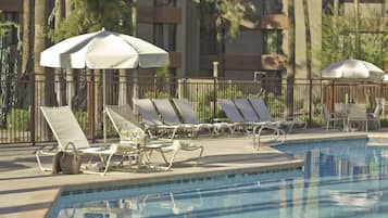 Een buitenzwembad, ligstoelen bij het zwembad