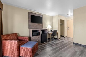 Une chambre d’hôtel équipée d’un canapé, d’un bureau, d’une télévision, d’une lampe et d’un réfrigérateur.