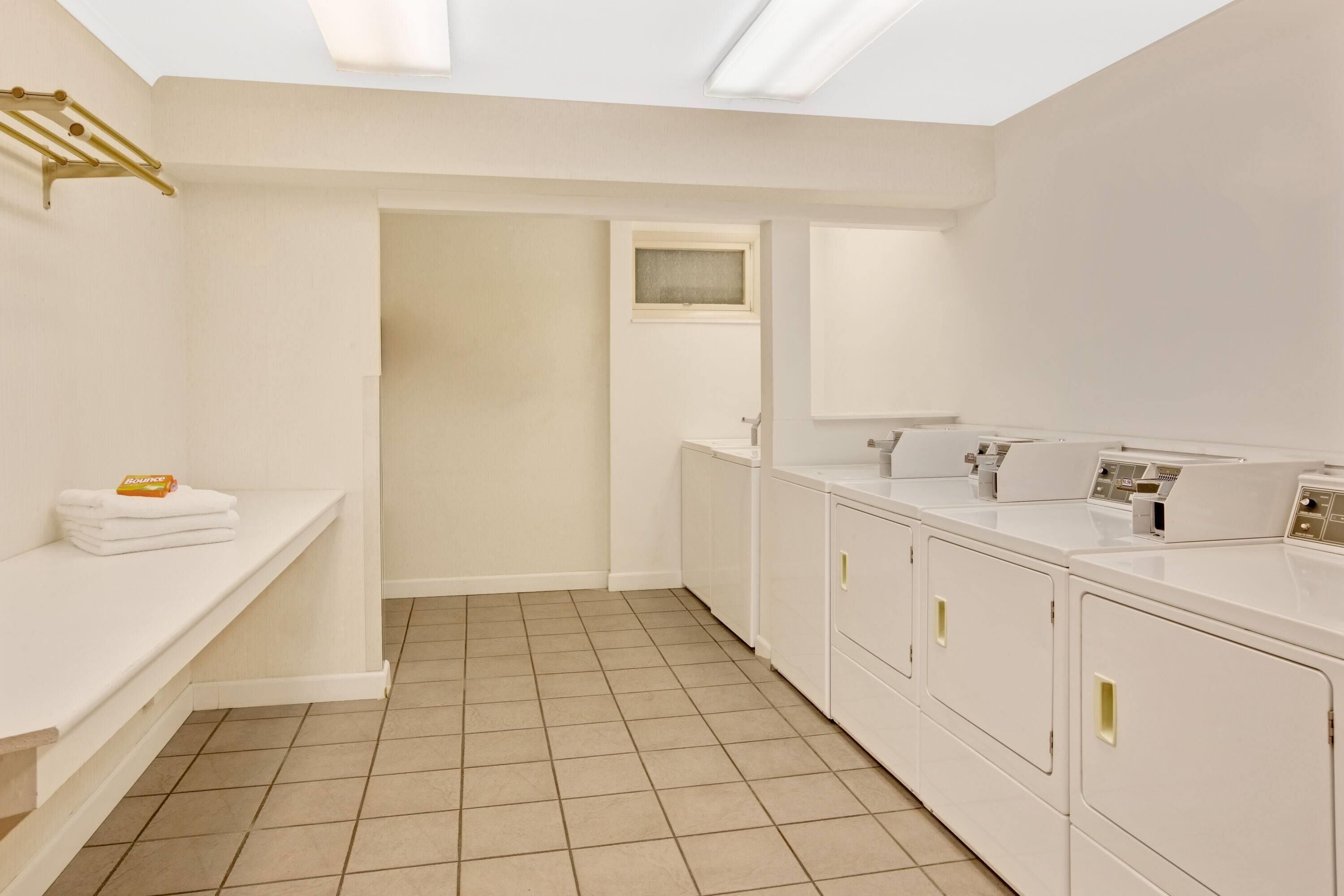 Une salle de bain moderne avec un lavabo blanc, un miroir et un lave-linge encastré.