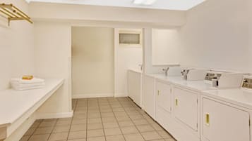 A modern bathroom with a white sink, mirror, and a built-in washing machine.