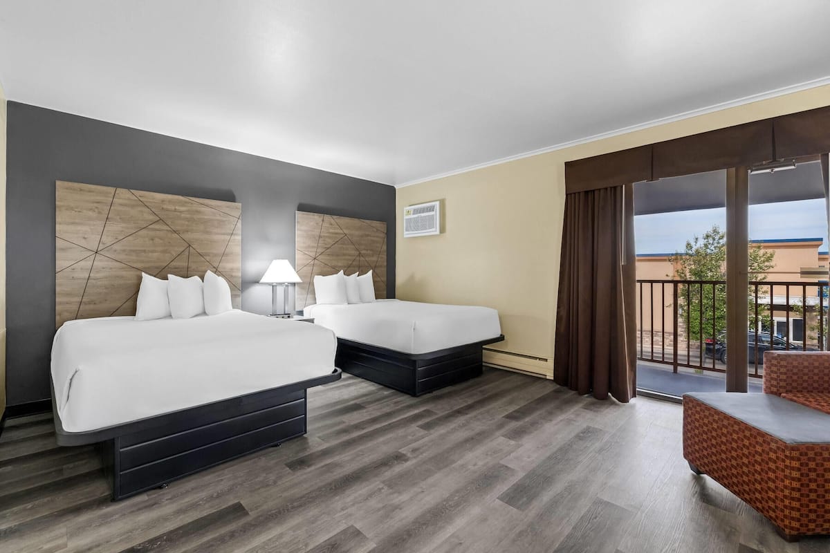 Ein Hotelzimmer mit zwei Betten, einem Balkon und Blick auf die Straße.