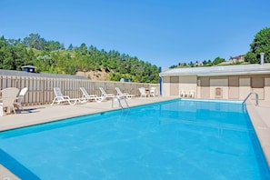 Piscine extérieure en saison, chaises longues