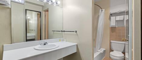 A bathroom with a white sink, mirror, and lights above the mirror.