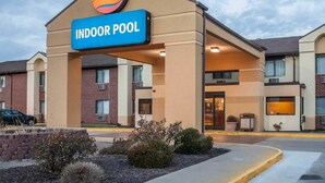 A hotel with an indoor pool, featuring a prominent sign and a brick facade.