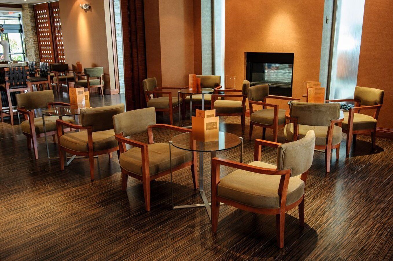A hotel lobby with multiple seating areas, a fireplace, and a television.