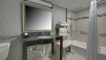 A bathroom with a sink, mirror, towel rack, and a shower with a curtain.