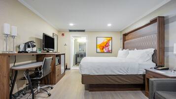 Une chambre d’hôtel équipée d’un lit, d’un bureau, d’une chaise et d’un téléviseur.