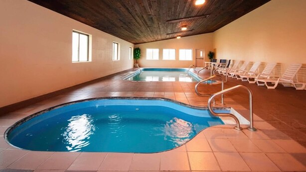An indoor swimming pool with multiple lanes, a wooden ceiling, and sunlit windows. - Quality Inn Milan - Sandusky (Milan)