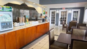 A hotel lobby with a reception desk, seating area, and exit doors. - Quality Inn Milan - Sandusky (Milan)