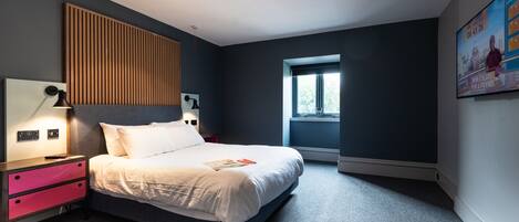Un dormitorio moderno con cama, mesitas de noche y una ventana.