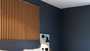 Un dormitorio con una cama, una lámpara de pared y un accesorio de techo rojo.