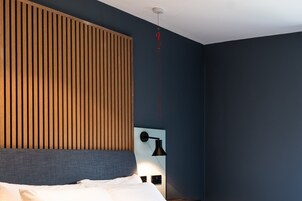 Un dormitorio con una cama, una lámpara de pared y un accesorio de techo rojo.