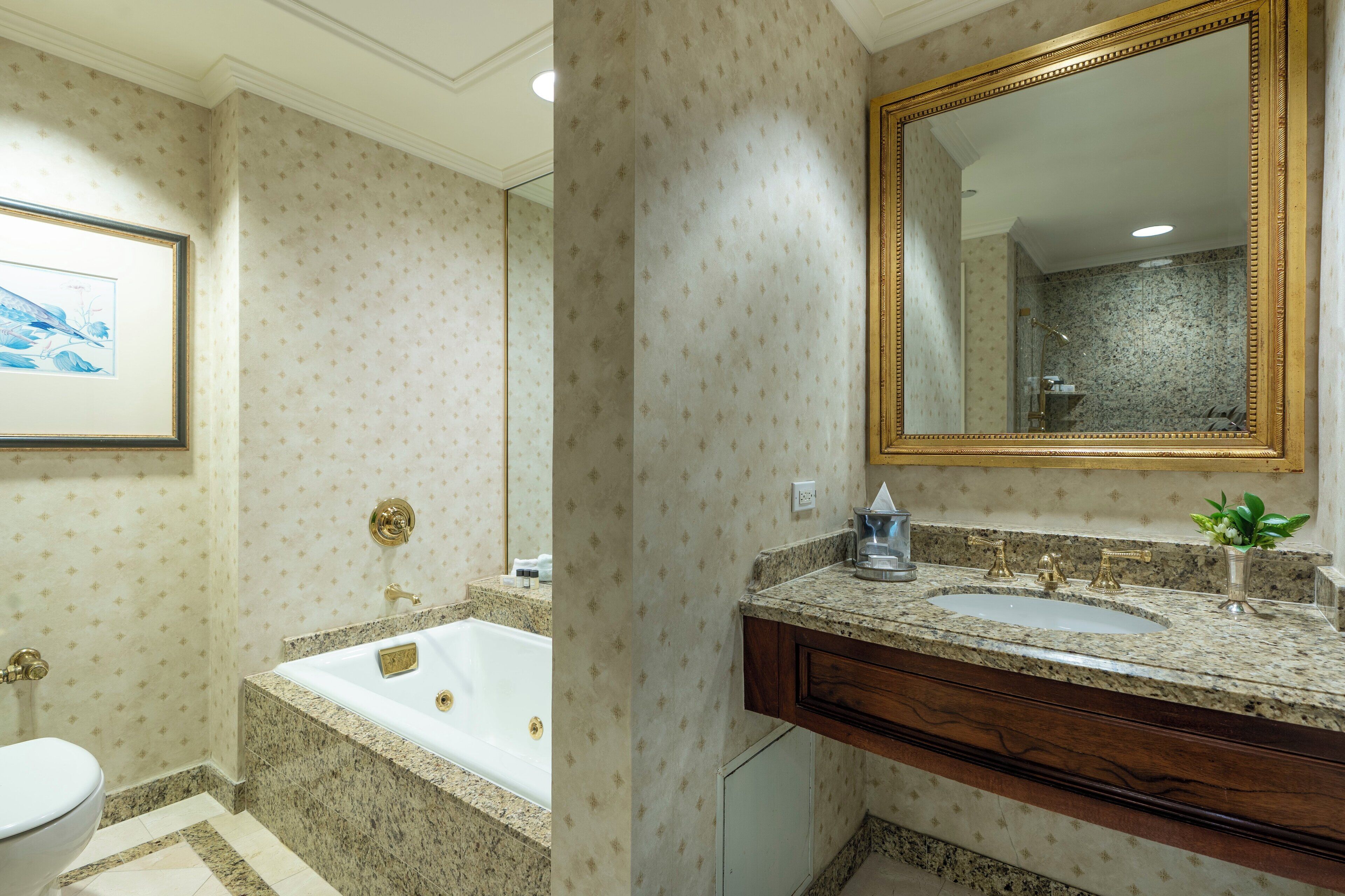 A bathroom with a bathtub, a sink, and a large mirror.