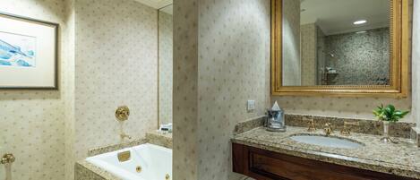 A bathroom with a bathtub, a sink, and a large mirror.