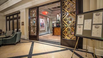 A lobby with a reception desk, seating area, and decorative glass panels.