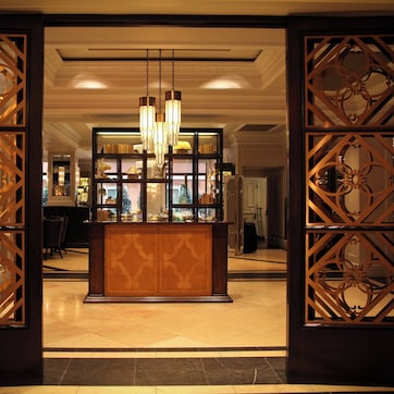 An open doorway with intricate wooden designs, a central light fixture, and a reflective surface behind it.
