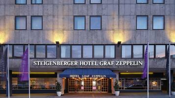 L'extérieur de l'hôtel Steigenberger Graf Zeppelin se distingue par sa façade moderne, ses grandes fenêtres et son entrée imposante.