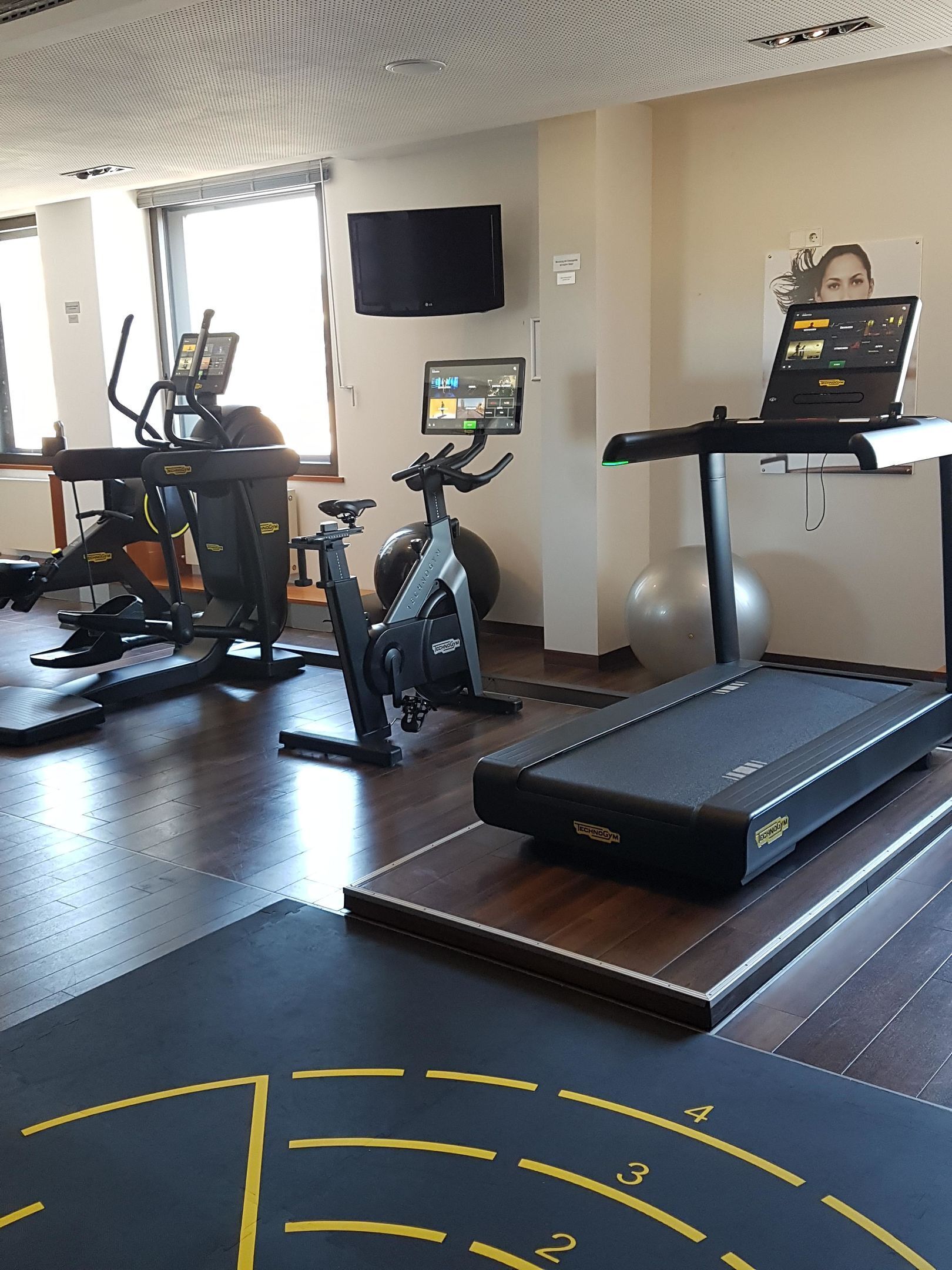 A gym with exercise equipment including a treadmill, stationary bike, and elliptical machine.