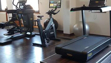A gym with exercise equipment including a treadmill, stationary bike, and elliptical machine.