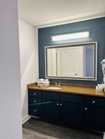 Bañera con ducha, artículos de tocador de diseñador, secador de pelo