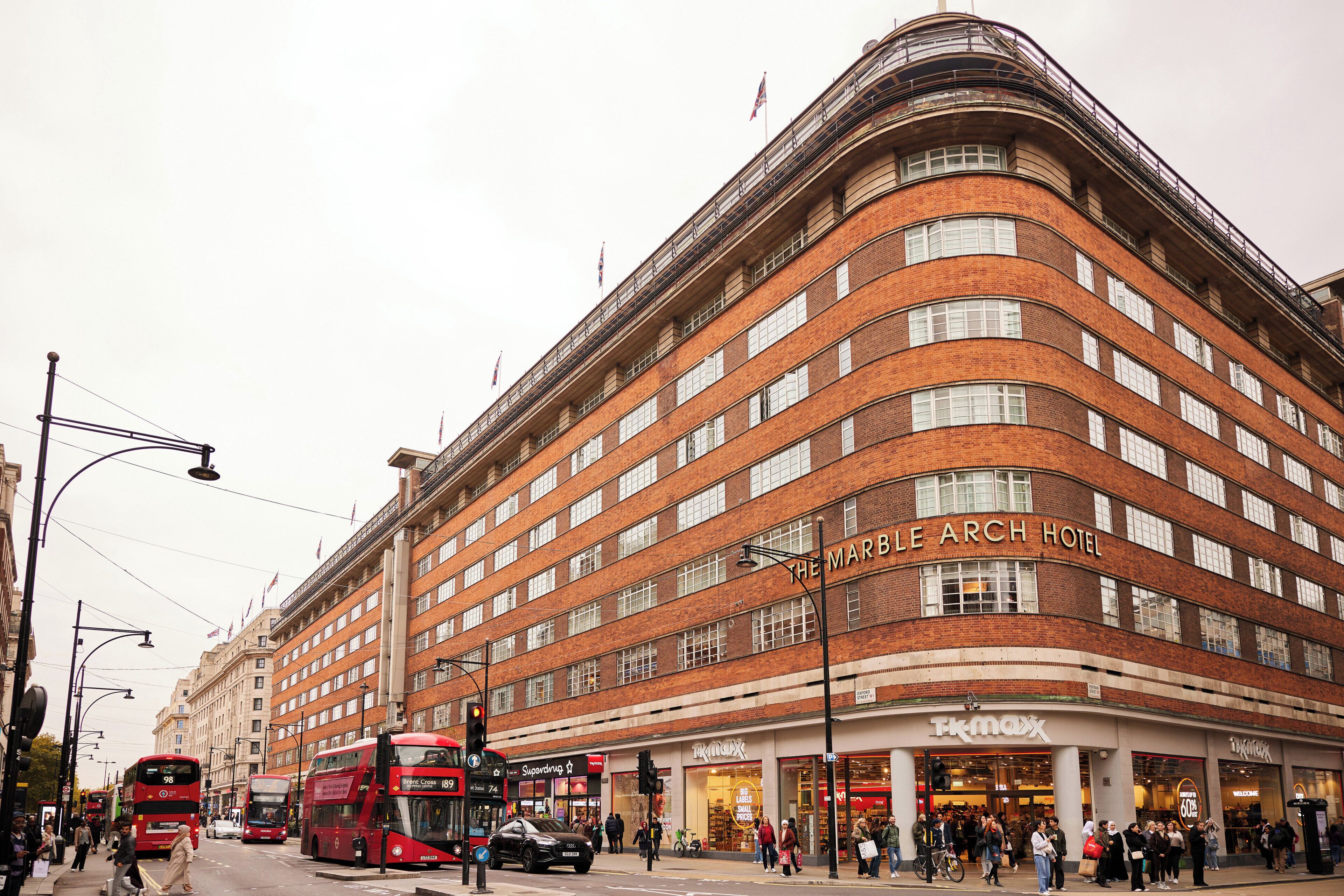 A multi-story hotel with a curved facade, multiple windows, and a prominent hotel name displayed.