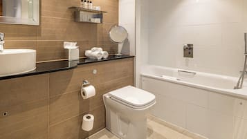 A modern bathroom with a sink, toilet, and bathtub.