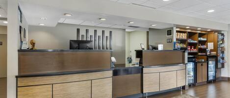 A reception area with a counter, a refrigerator, and a snack bar.
