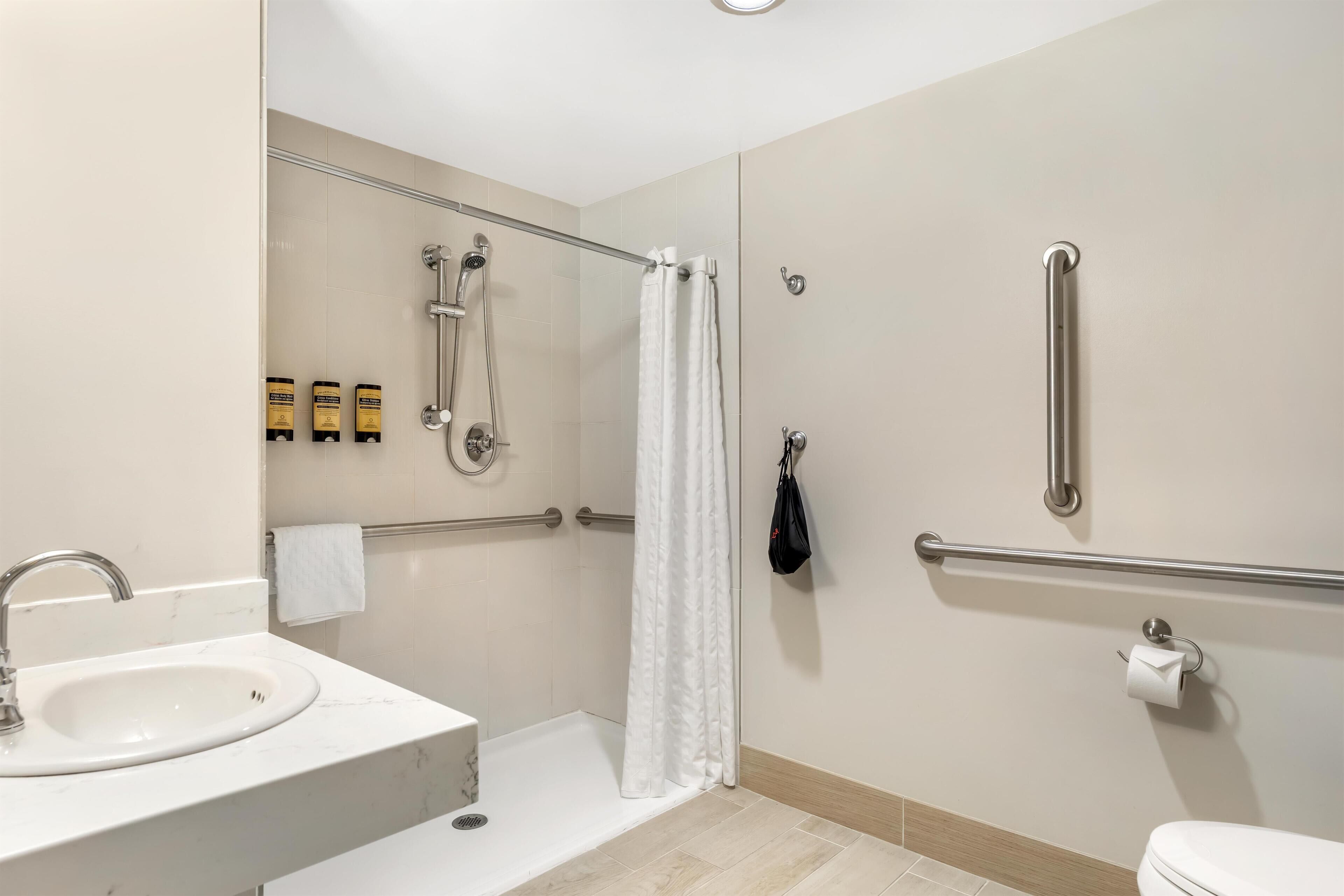 Un bagno moderno con lavandino, doccia e servizi igienici.