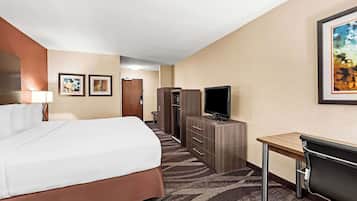 A hotel room with a bed, a desk, a television, and a wardrobe.