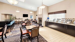 A hotel room with a dining area, a fireplace, and a kitchenette. - Best Western Maple City Inn (Hornell)