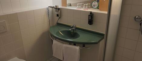 A small bathroom with a green sink, a toilet, and a mirror above the sink.