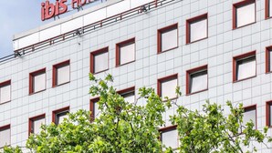 A hotel building with a sign reading 'ibis HOTEL' and multiple windows with red frames. - ibis Berlin Messe (Berlin)