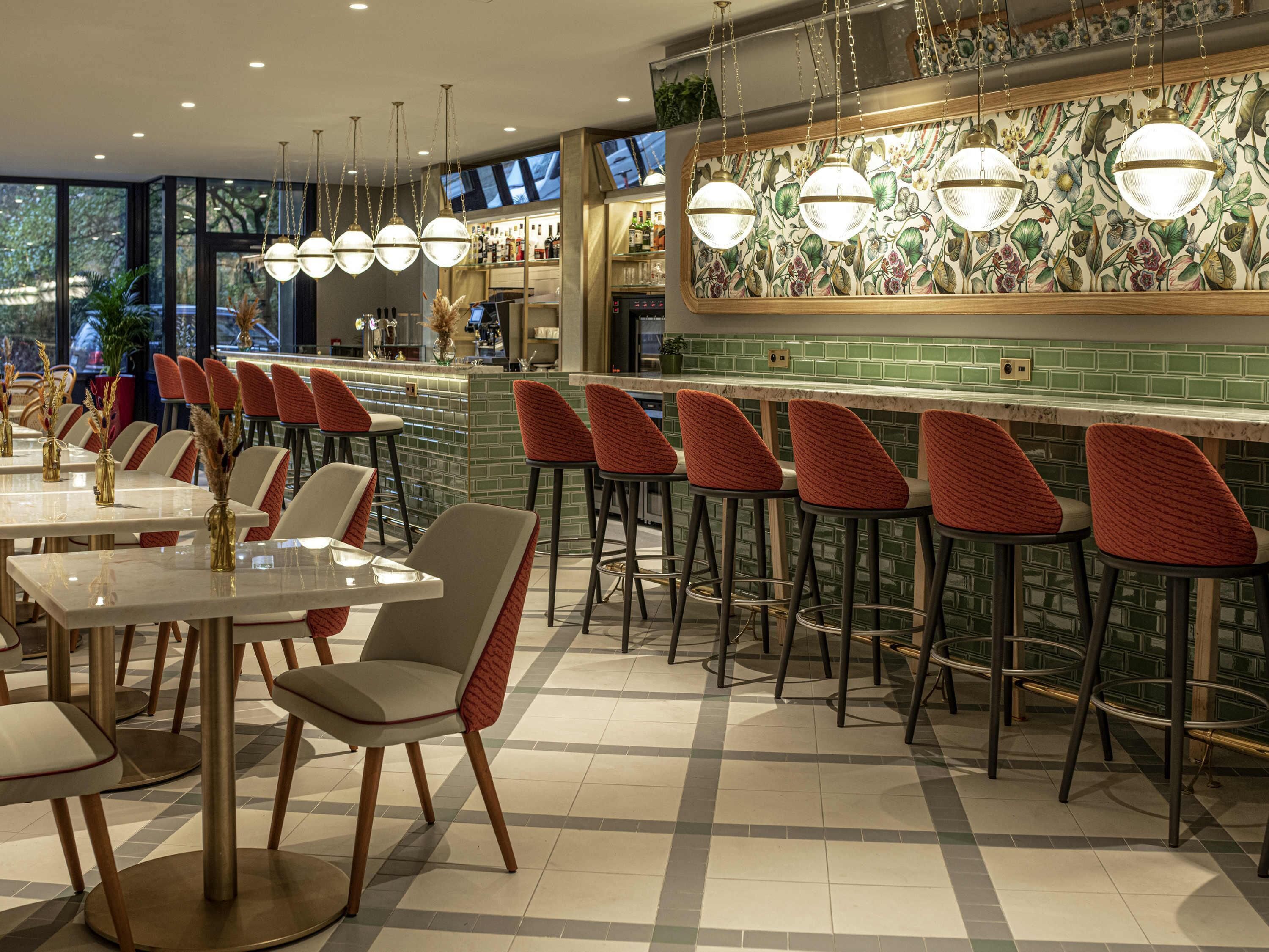 Een restaurant met een bar, betegelde vloer en hangende吊り下げ型lampen.