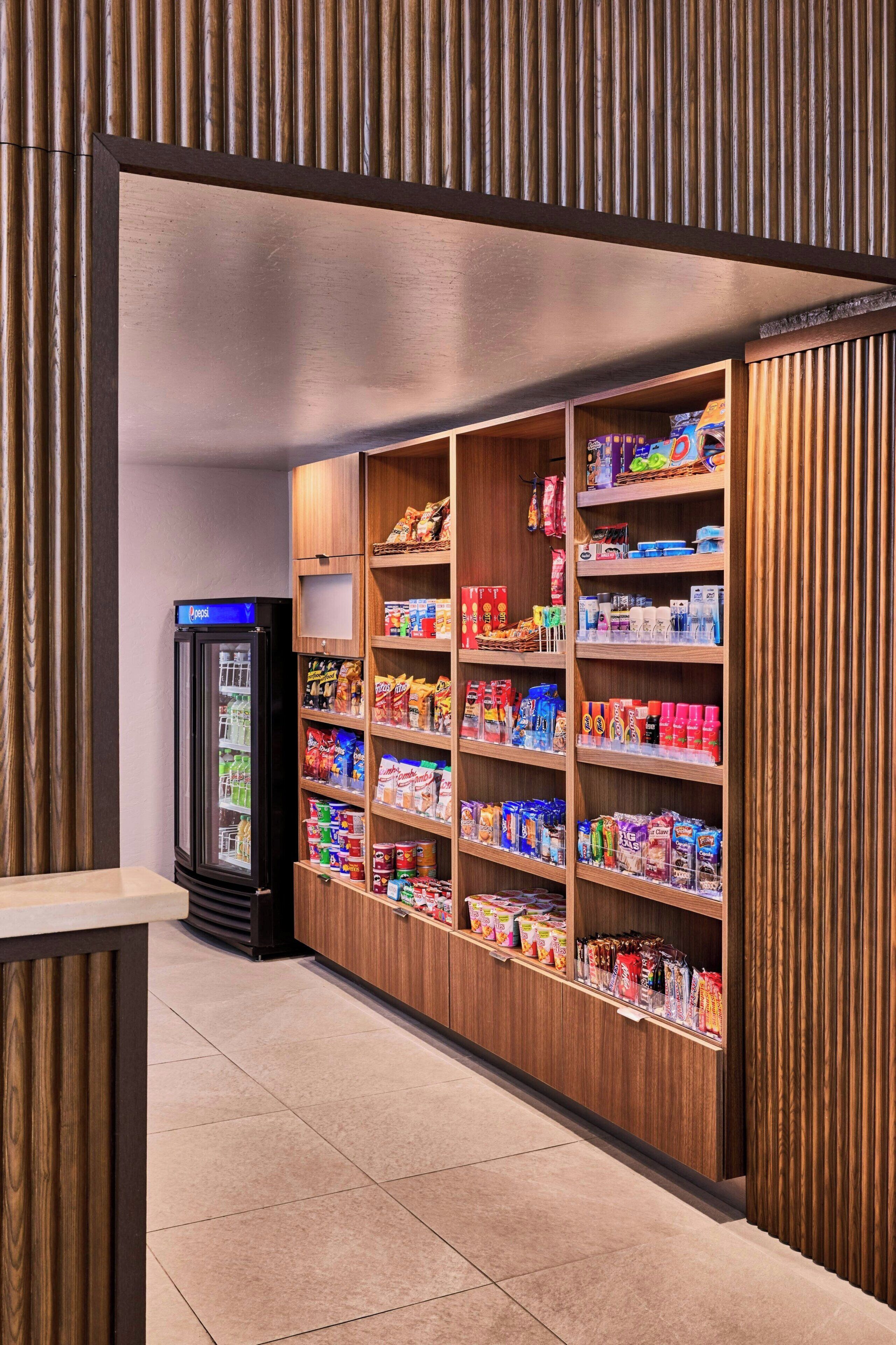 A snack kiosk with a variety of packaged goods and a Pepsi refrigerator.