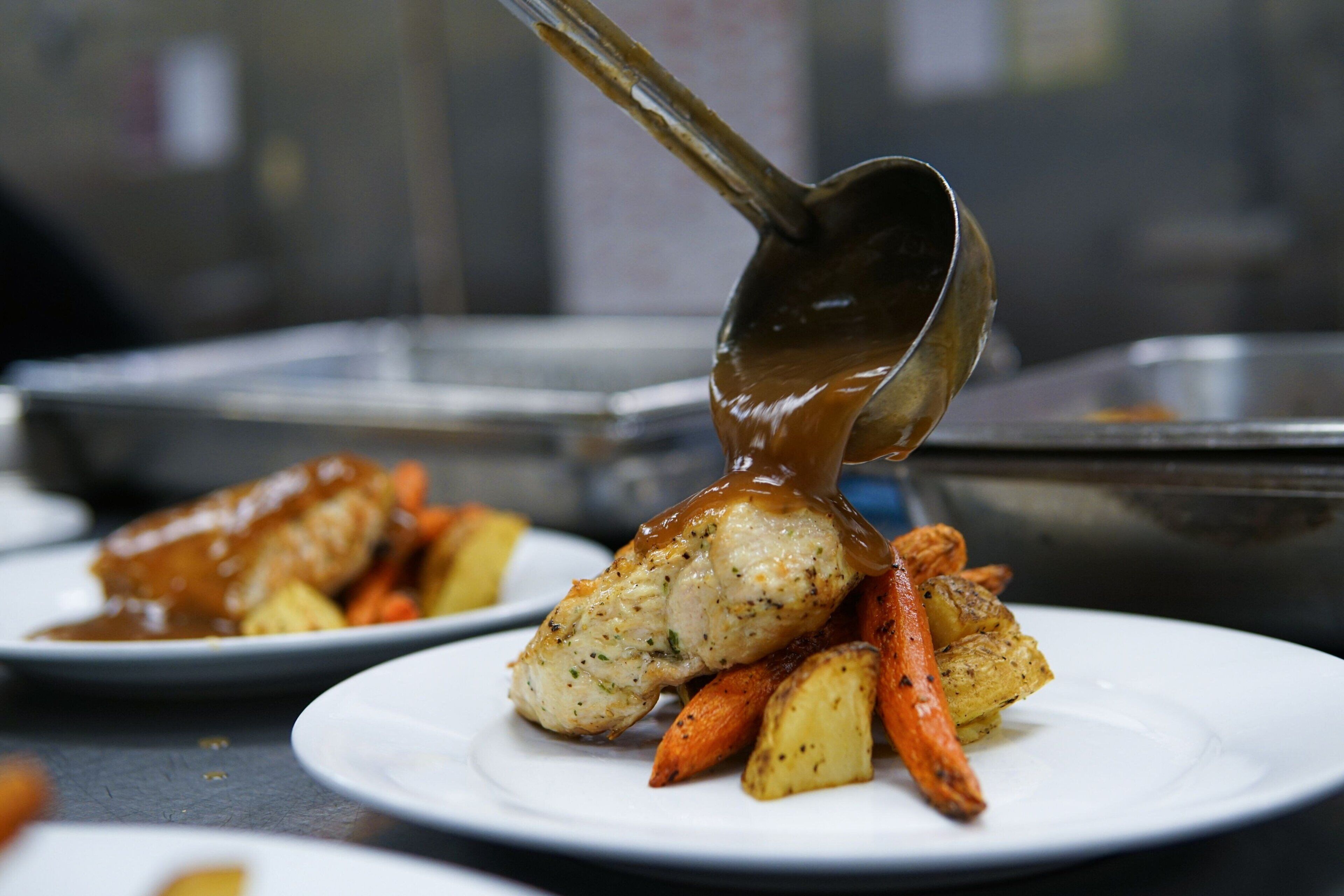 Un plato con pollo asado, zanahorias y papas.