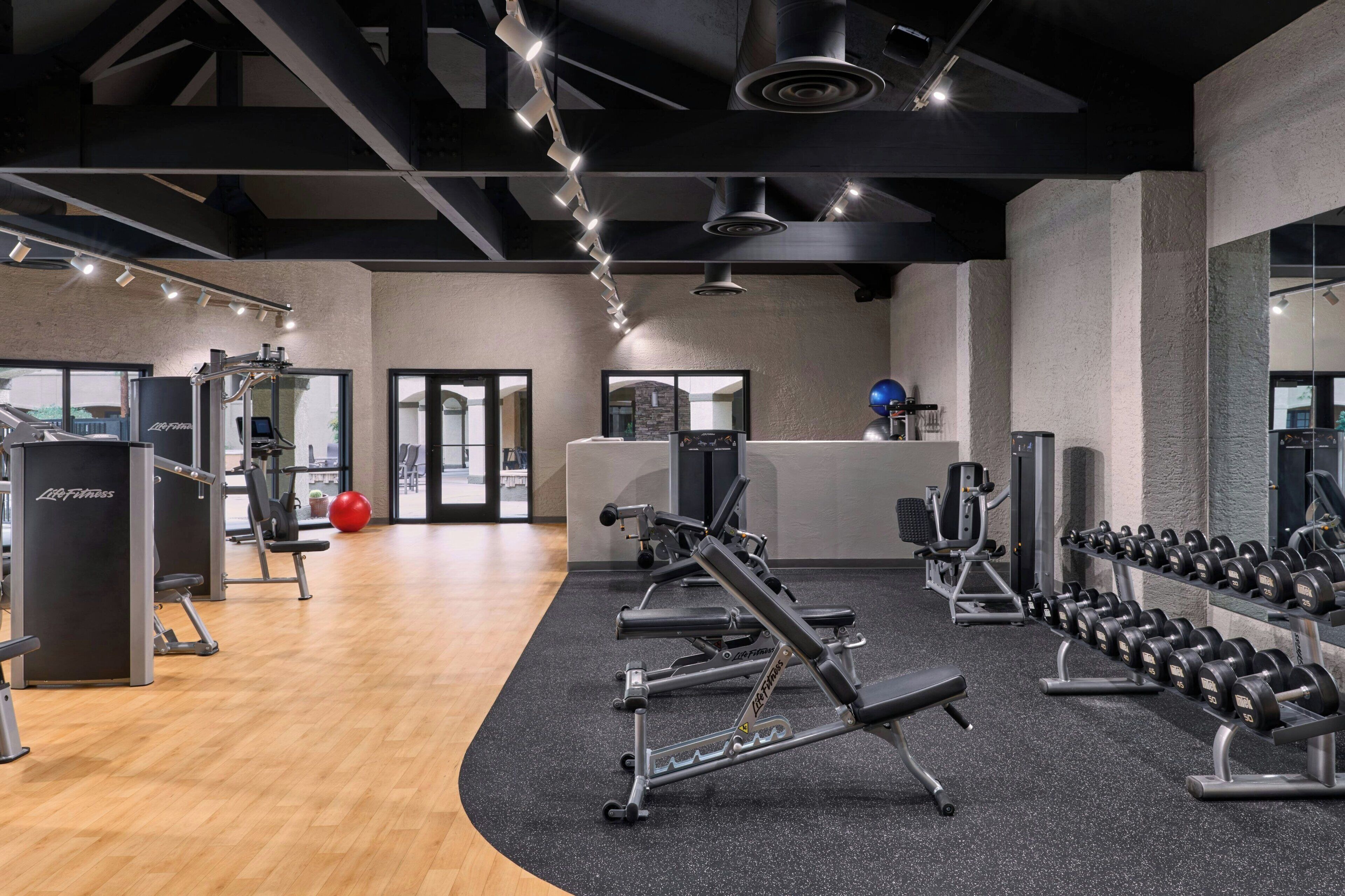 A gym with various exercise equipment, including dumbbells and weight machines.