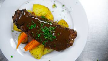 Une assiette contenant un plat de viande, des pommes de terre et des carottes.