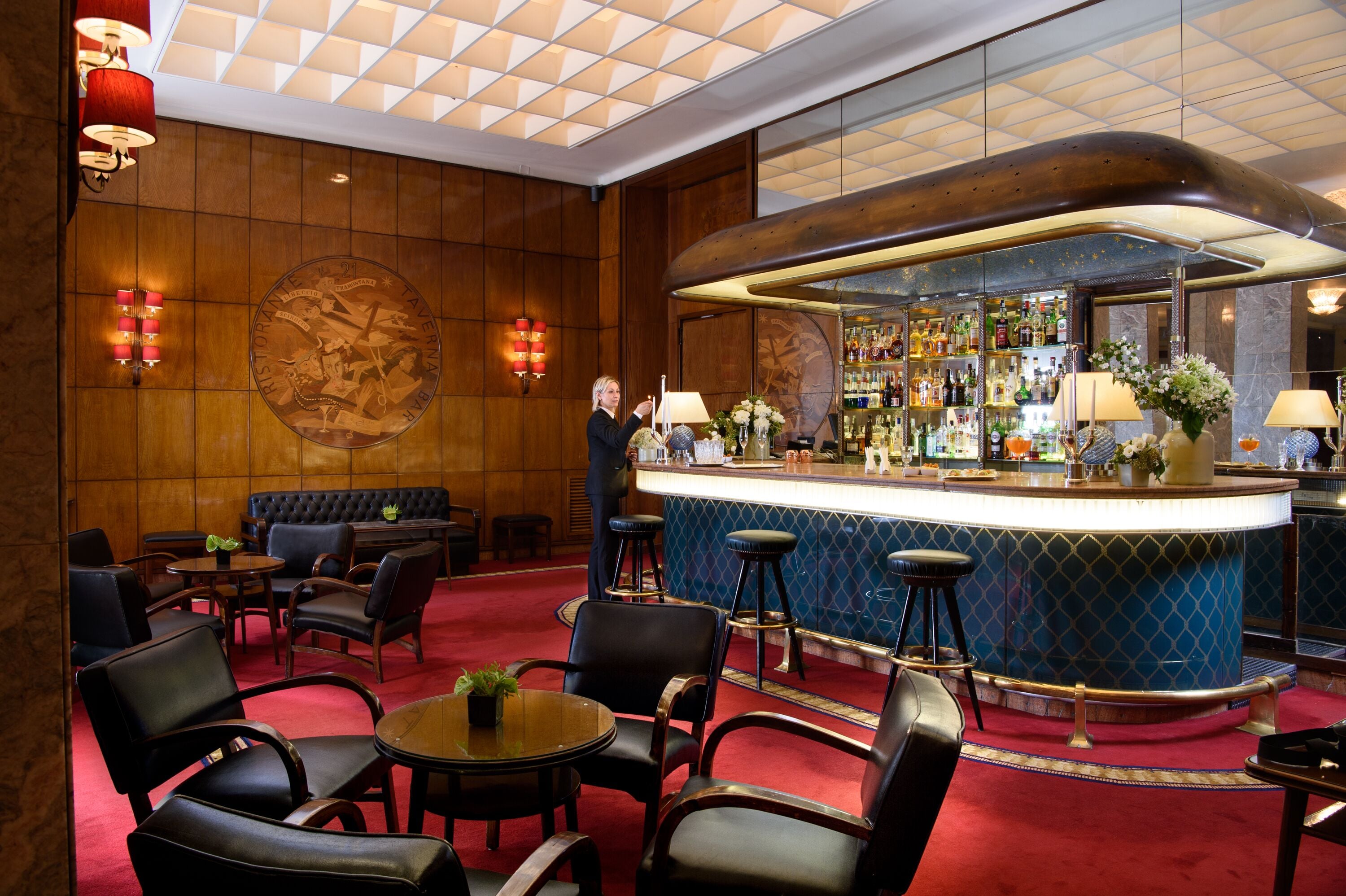 A bar area with a counter, stools, and a seating area with tables and chairs.