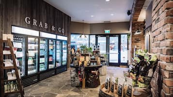 A store interior with a 'Grab & Go' sign, refrigerated display cases, and a variety of products on shelves and tables.