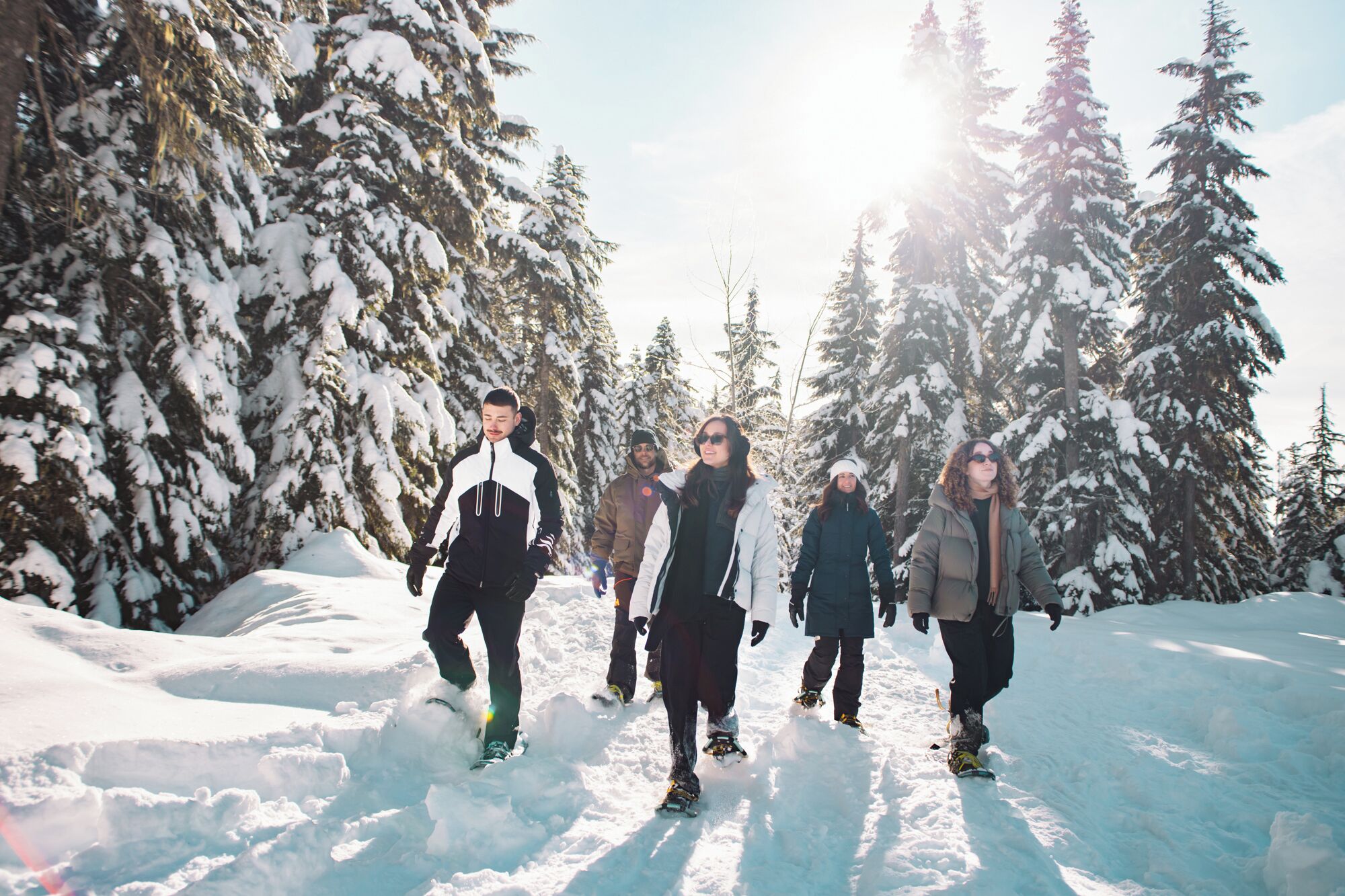 Un grupo de personas caminando en un bosque nevado.
