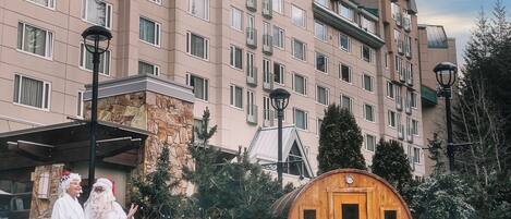 Un hôtel doté d’une grande piscine, d’une structure en forme de tonneau en bois et d’une façade en pierre.
