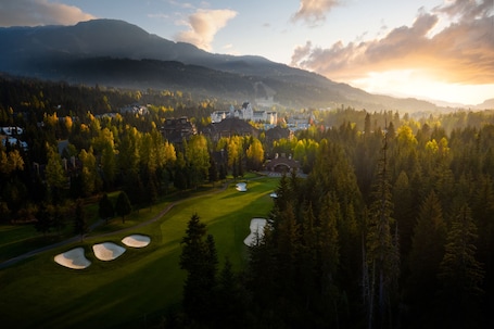 A golf course with bunkers and a town in the background.