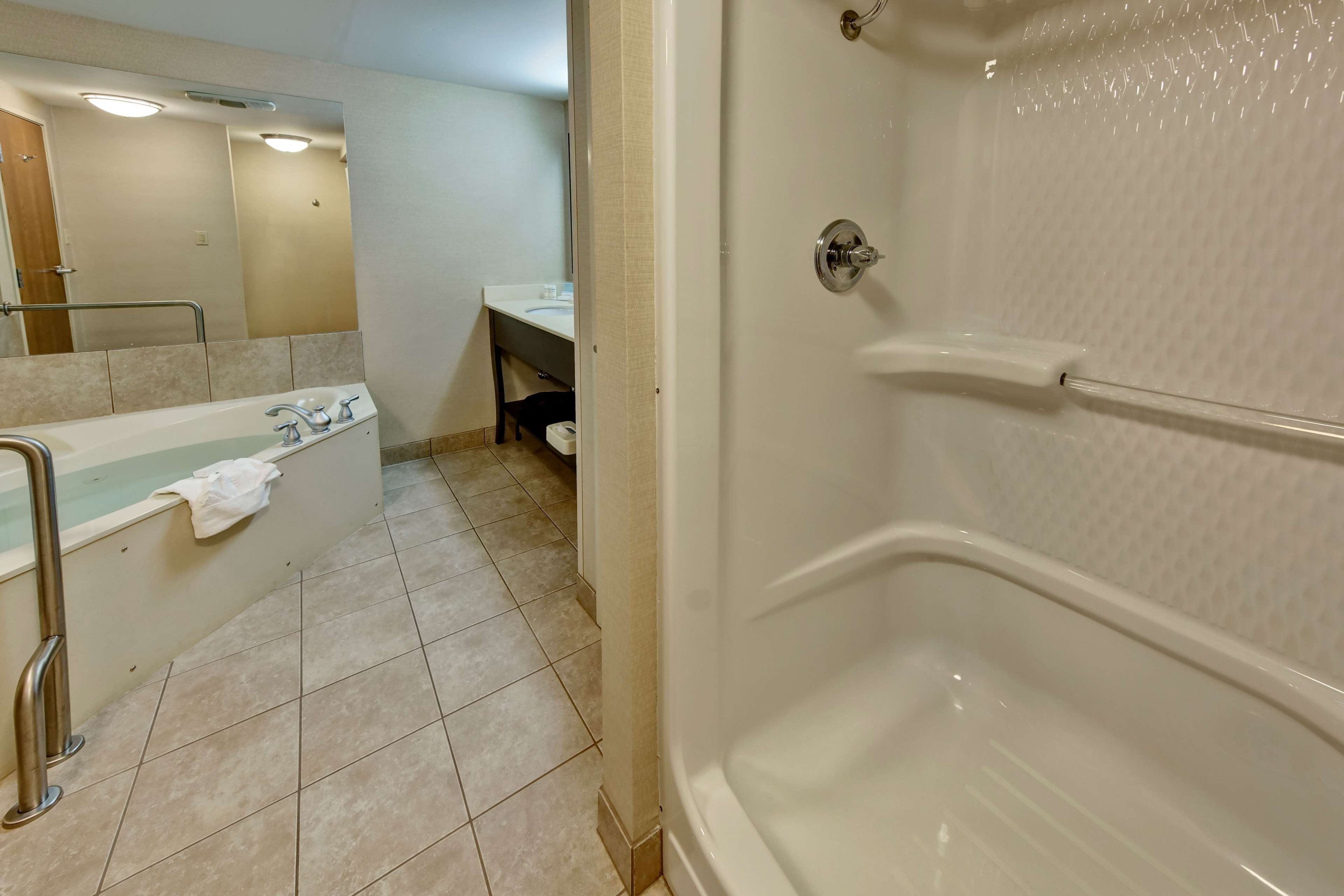 Un baño con bañera, ducha, lavabo y espejo.