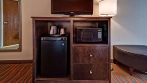 Un elegante minibar con televisione, forno a microonde e macchina del caffè.