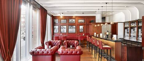 A spacious bar area with red leather seating and a wooden bar counter.