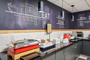 A breakfast bar with a chalkboard wall, a toaster, and a coffee machine. - Hampton Inn Cleveland-Westlake (Westlake)