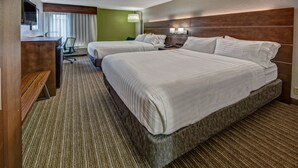 Una habitación de hotel con dos camas, un escritorio, una silla y un televisor.