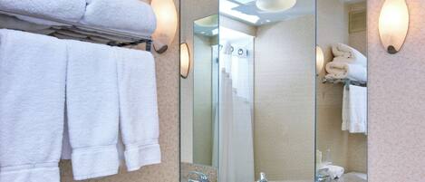 A bathroom with a sink, mirror, towel rack, and wall sconces.