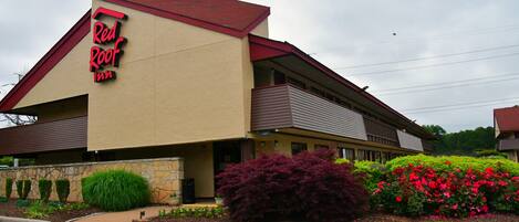 A Red Roof Inn with a red roof, beige walls, and a signboard.